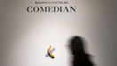 NEW YORK, NEW YORK - OCTOBER 25: People view Maurizio Cattelan&apos;s &quot;Comedian&quot; during a press preview for Sotheby&apos;s Evening Auction on October 25, 2024 in New York City. The conceptual piece, a banana duct-taped to a wall, went viral in 2019 and one of its three editions is estimated to sell for between $1 million to $1.5 million. (Photo by John Nacion/Getty Images)